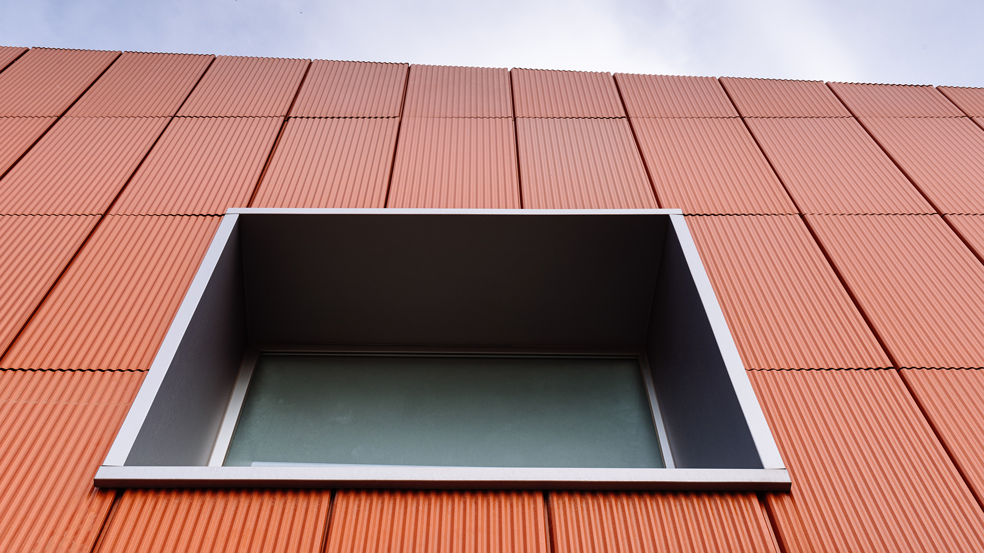 Terracotta Fassade mit Aluminium Fensterrahmen